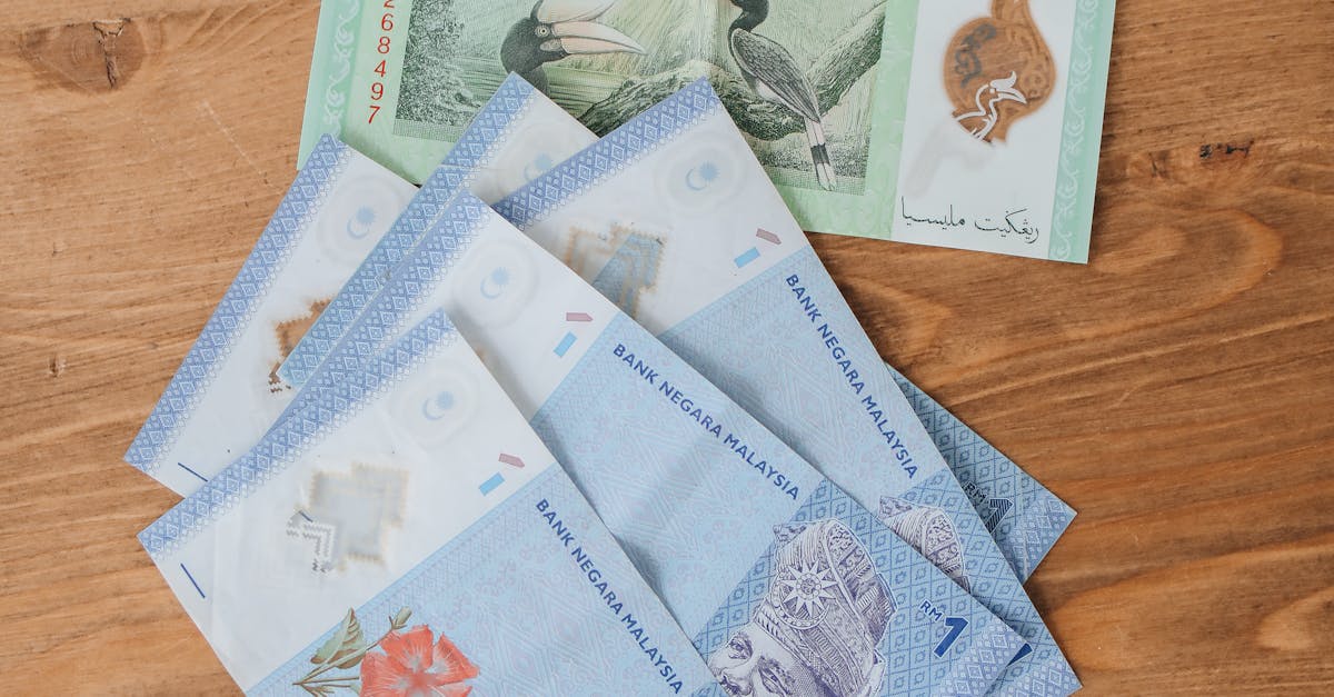 Several Malaysian Ringgit banknotes arranged on a wooden surface, showcasing various denominations.